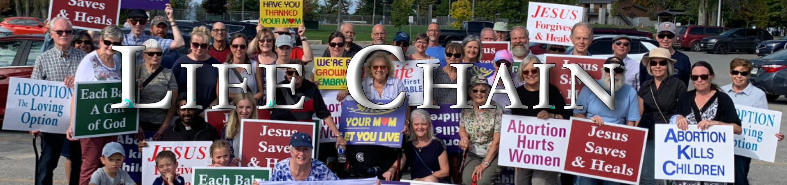 Life Chain showing 30 people holding anti abortions signs in a park