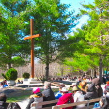 Teopoli Cross surrounded by people praying outdoors